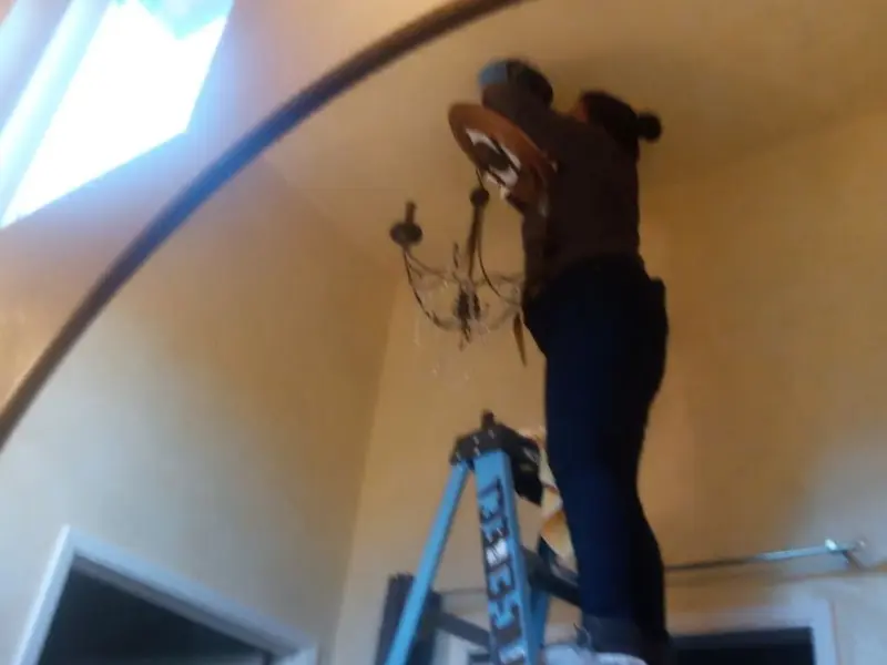 Electrician installing a chandelier in a Upper Mount Bethel residence